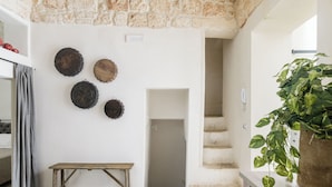 A kitchen with a wooden bench, a staircase, and a potted plant. - Terrazza 42 by Wonderful Italy (Ostuni)