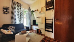 A living room with a sofa, a coffee table, a TV, and a wooden door. - Apartment Lončar with sea view (Krk)