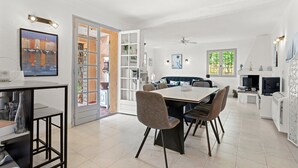 A modern kitchen with a dining area, a built-in bookshelf, and a large window. - Holiday Home 'La Belle Provence' with Sea View, Wi-Fi and Air Conditioning (Roquebrune-sur-Argens)