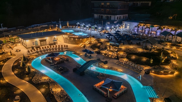 A resort with a large swimming pool, outdoor seating areas, and a building with multiple levels. - Special Offer•6BD•Pool•Theater•Games•Views (Sevierville)