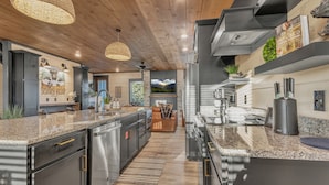 A modern kitchen with granite countertops, stainless steel appliances, and a central island. - Special Offer•6BD•Pool•Theater•Games•Views (Sevierville)
