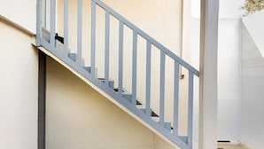 Un escalier avec une rampe et des marches bleu clair, menant à un niveau supérieur.