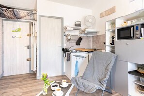 A compact kitchen with a microwave, stove, and sink.