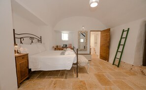 A bedroom with a bed, nightstand, dresser, and a mirror. - Villa 'Trullo Agapanthus with Panoramic' with Private Pool, Wi-Fi and Air Conditioning (Ostuni)