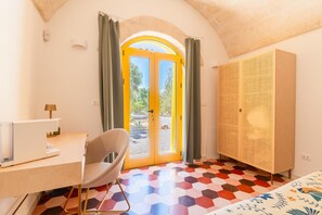 Ein Zimmer mit Schreibtisch, Stuhl und großem Kleiderschrank.