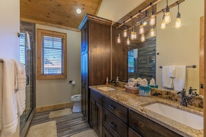 Une salle de bain avec un double lavabo, des meubles en bois et un grand miroir.