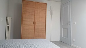A bedroom with a large wardrobe, a radiator, and a door.