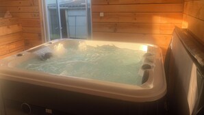 Een houten chalet met een jacuzzi.