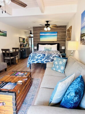 A cozy living room with a sofa, a coffee table, and a dining area with chairs and a table.