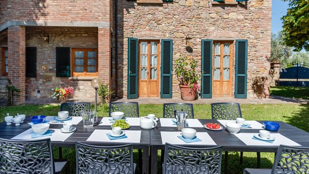 A stone building with green shutters, a table set for dining, and outdoor seating. - Country House 'La Pineta Farm House' with Private Pool and Wi-Fi (Varna)