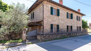 A stone building with a balcony, a gated entrance, and a clear sky. - Country House 'La Pineta Farm House' with Private Pool and Wi-Fi (Varna)
