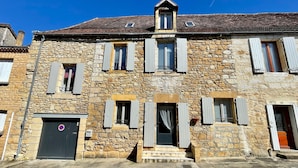A stone building with multiple windows and a door, featuring a traditional architectural style. - La Cyprienne – Spacious House with Rooftop Terrace (Saint-Cyprien)
