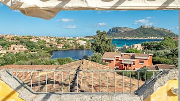 Una cittadina costiera con edifici, un lago e una montagna sullo sfondo.