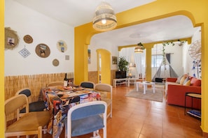 Un comedor con una mesa cubierta por un mantel colorido, rodeada de sillas.