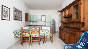 Uma cozinha compacta com uma mesa de jantar, cadeiras e um armário de madeira.