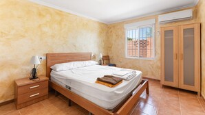 A bedroom with a bed, bedside tables, a wardrobe, and a window with a view. - Country House 'La Romana' with Private Pool, Wi-Fi and Air Conditioning (La Romana)