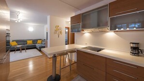Una cocina moderna con una isla central, horno empotrado y un ventanal grande.