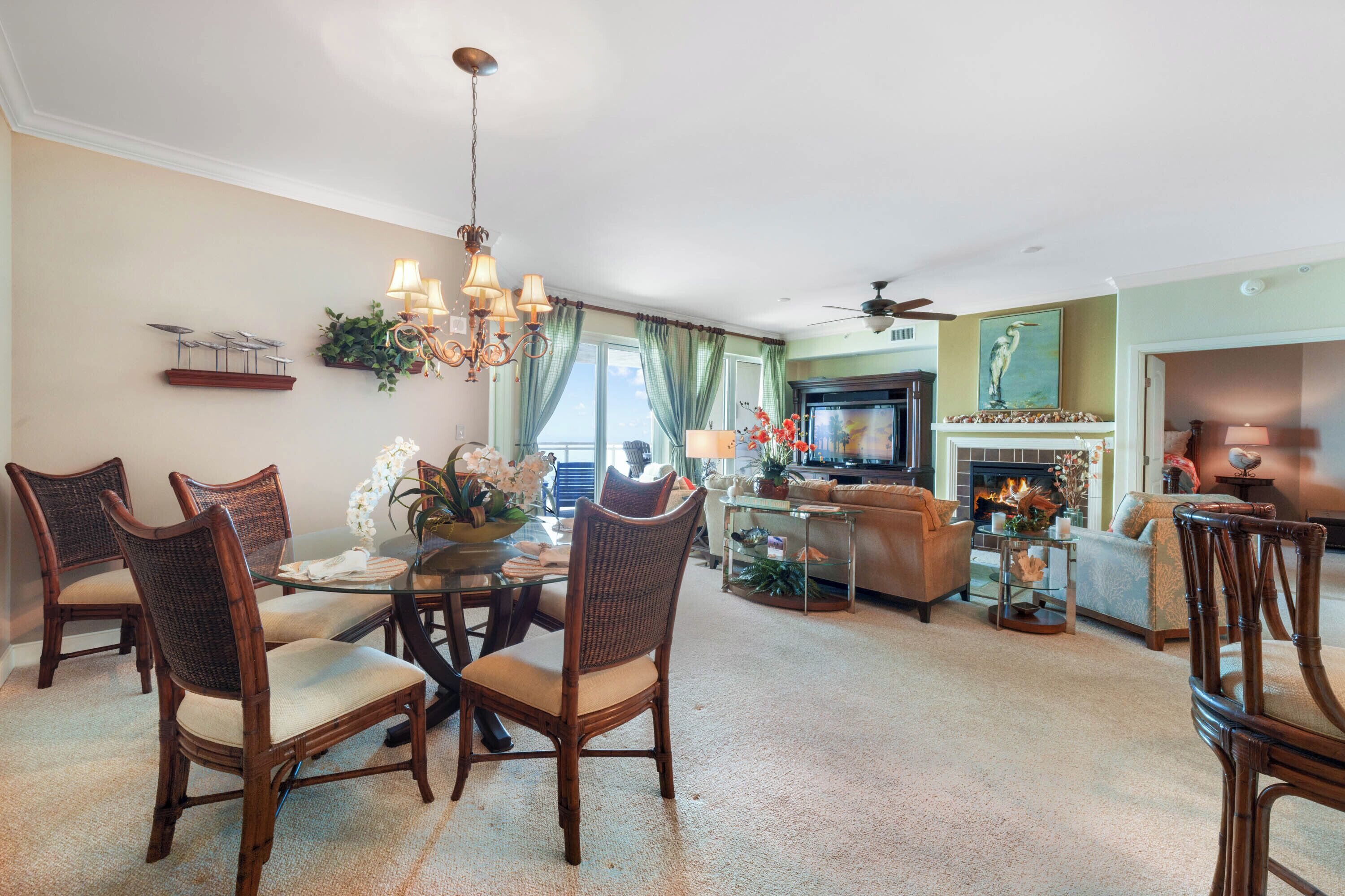 A spacious living room with a dining area, a fireplace, and a television.