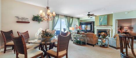A spacious living room with a dining area, a fireplace, and a television.