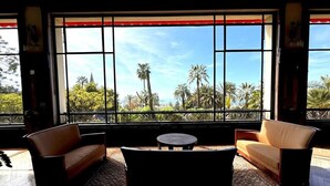 A room with a large window, two sofas, a small table, and a patterned rug. - StudioCalifornia-Parking-Plages 15 min walk (CANNES)