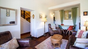 Un salon avec des canapés en cuir, une table à manger et un escalier.