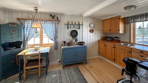 Une cuisine chaleureuse avec des meubles en bois, une table à manger et une machine à café.