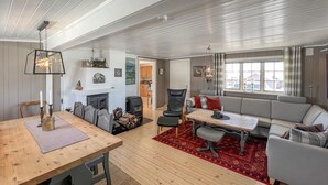 Un vaste espace de vie comprenant une cheminée, une table à manger et un canapé.