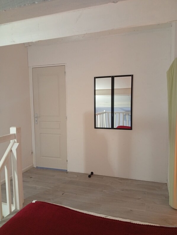 Ein Zimmer mit geschlossener Tür, einem gerahmten Bild an der Wand und einem roten Teppich auf dem Boden.