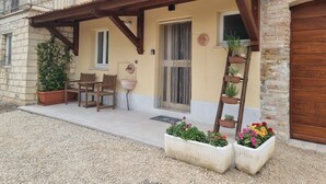 Un bâtiment doté d’un patio couvert, d’un espace extérieur aménagé pour s’asseoir, d’une fontaine et de plantes en pot.