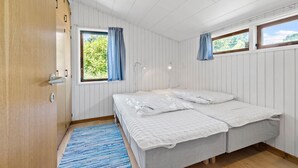 A room with a bed, a window with curtains, a door, and a blue rug. - 4 bedroom stunning home in Gilleleje (Gilleleje)