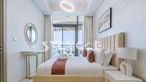 Une chambre d’hôtel moderne avec un grand lit, une table de chevet, un miroir et une vue sur la ville.