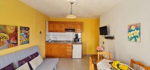 A compact living space with a kitchenette, a dining area, and a sofa. - Apartment 'Apartamento 6' with Shared Pool, Private Terrace and Wi-Fi (Los Llanos)