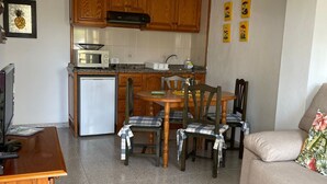 A compact living space with a kitchenette, dining area, and seating. - Apartment 'Apartamento 1' with Shared Pool, Private Terrace, and Wi-Fi (Los Llanos)