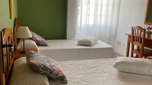 A room with two beds, a desk, a chair, a lamp, and a window with curtains. - Apartment 'Apartamento 1' with Shared Pool, Private Terrace, and Wi-Fi (Los Llanos)