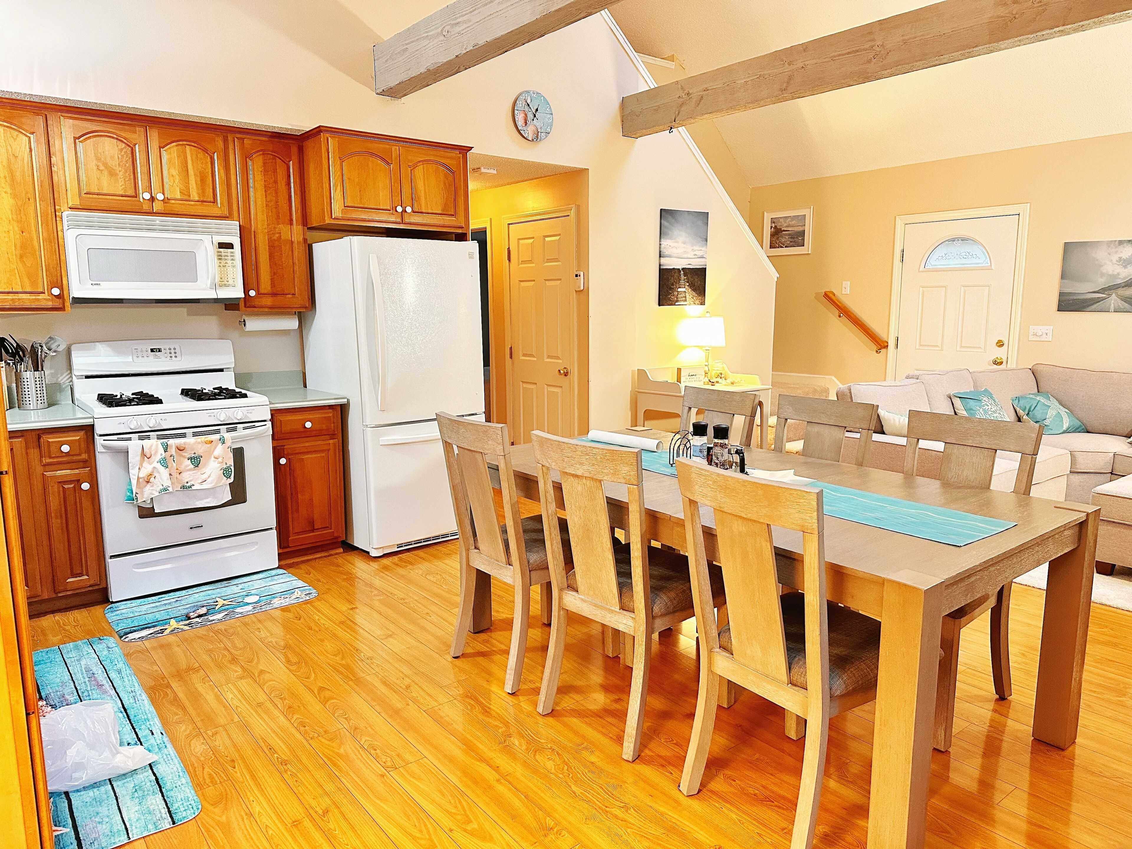 A compact kitchen with wooden cabinets, a stove, microwave, and refrigerator.