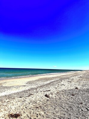 Una playa con cielo despejado y mar tranquilo.
