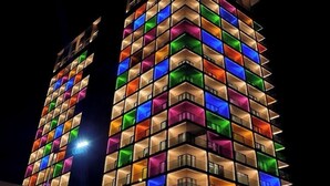 A multi-story building with a distinctive facade featuring a grid of illuminated windows in various colors. - Seybouse Hotel & SPA (Annaba)