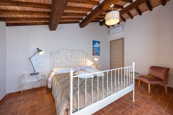 Une chambre à coucher avec un lit, des lampes de chevet, une chaise et une porte.