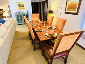 A dining area with a wooden table set for six, surrounded by six chairs with cushioned seats. - Soaring Eagle 301 Ski In Out! (Snowshoe)