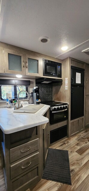 Fridge, microwave, oven, stovetop - Travel trailer near the creek, short walk to pool and playground, indoor and outdoor kitchenette, sleeps 8. (Mill Spring)