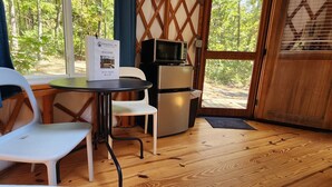 A compact kitchen with a refrigerator, microwave, and a welcome sign. - 16' Yurt, Dog Friendly, Deck, Dome Skylight, Sleeps 2. (Mill Spring)