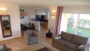 A modern living room with a sofa, armchair, and coffee table. A dining area with a table and chairs is visible in the background. - Séjour inoubliable en Provence | Maison + jardin (Roquebrune sur Argens)