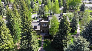 A residential area with houses surrounded by dense green trees and hills in the background. - Stylish Sun Valley Condo w/ Resort Access! (Sun Valley)