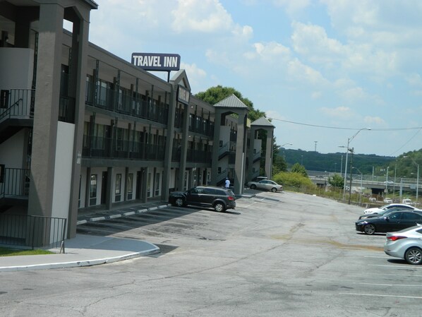 A Travel Inn with a multi-story building, a parking lot, and a view of the surrounding area. - Travel Inn Atlanta (Atlanta)
