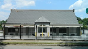 A building with a metal fence, a registration office, and a small entrance with a triangular roof. - Travel Inn Atlanta (Atlanta)