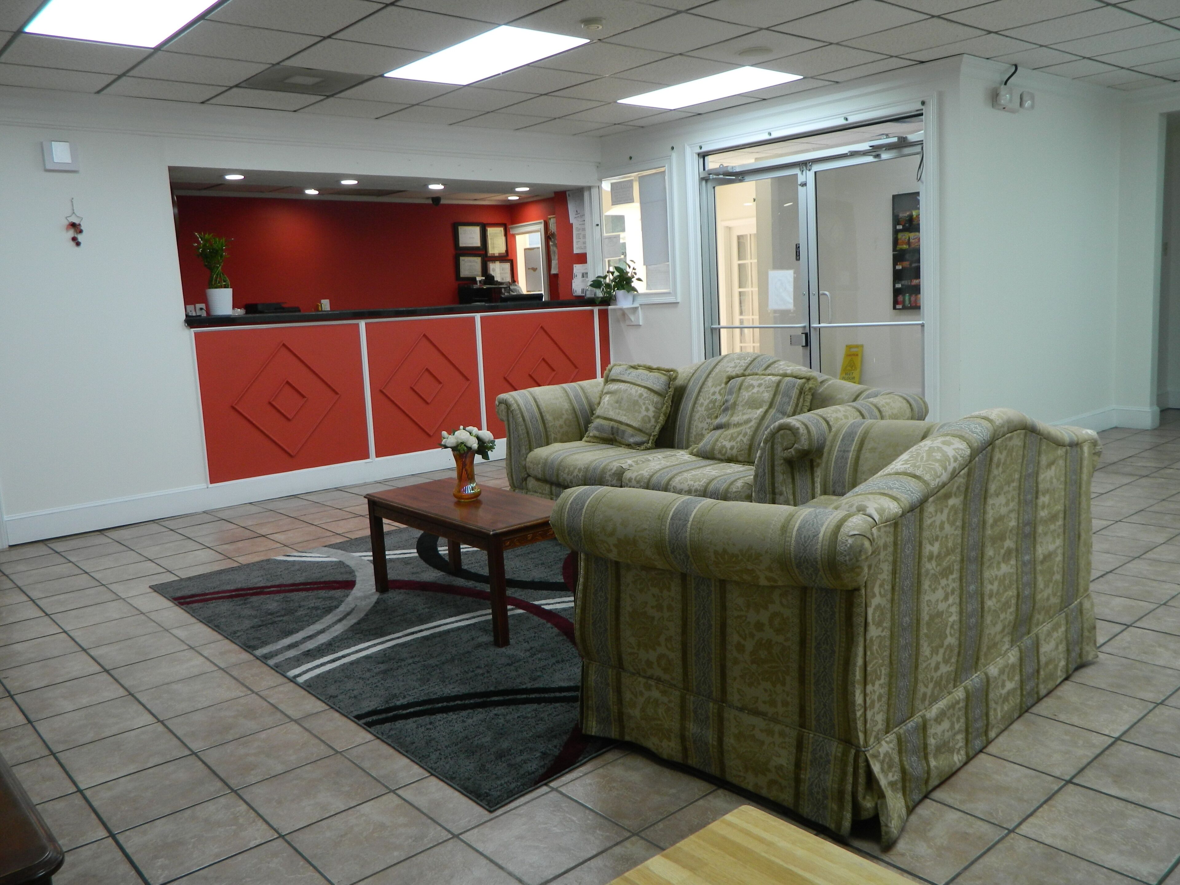 A furnished living area with a sofa set, a small table, and a rug.