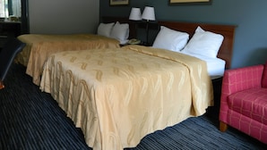 A hotel room with two beds, a desk, a chair, and two paintings on the wall. - Travel Inn Atlanta (Atlanta)