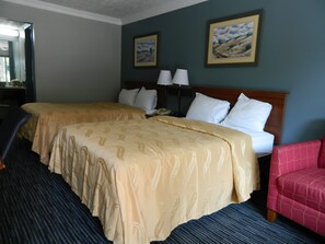 A hotel room with two beds, a desk, a chair, and two paintings on the wall. - Travel Inn Atlanta (Atlanta)