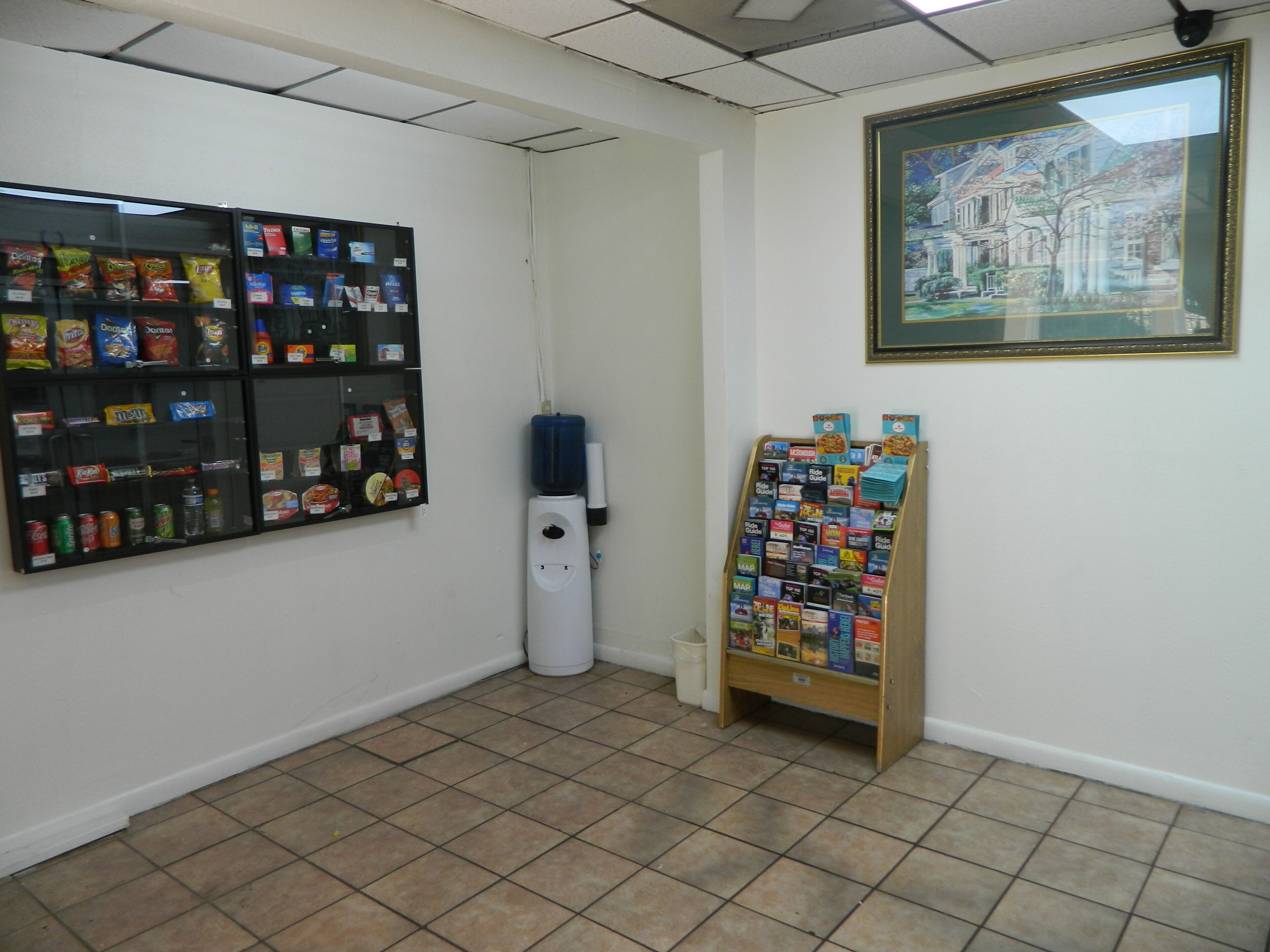 Quarto com máquina de vendas, bebedouro e mural com diversos itens.