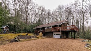 A two-story house with a wooden deck and a garage. - Four Bear Falls (Banner Elk)
